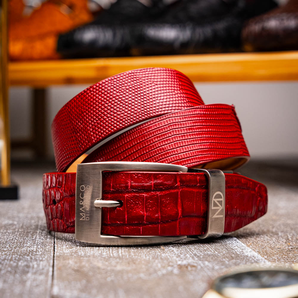 The Giovanni Belt Red by Marco Di Milano is a rolled red leather belt with a textured finish and a silver buckle, reflecting the refined style of genuine lizard ring-caiman belly belts.