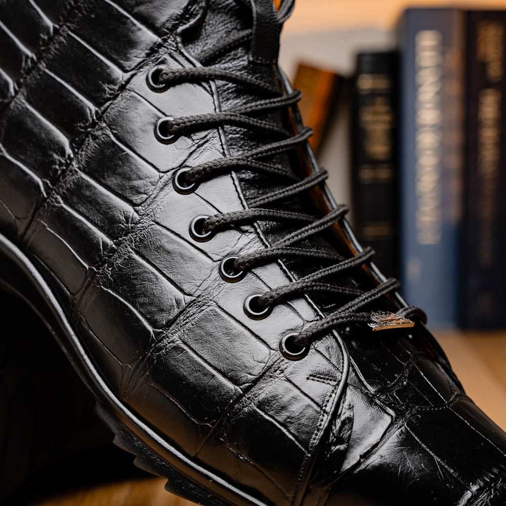 The Hermond Black boots by Marco Di Milano feature high-top, crocodile-patterned black leather and durable rubber soles—one boot stands upright while the other is propped beneath it.
