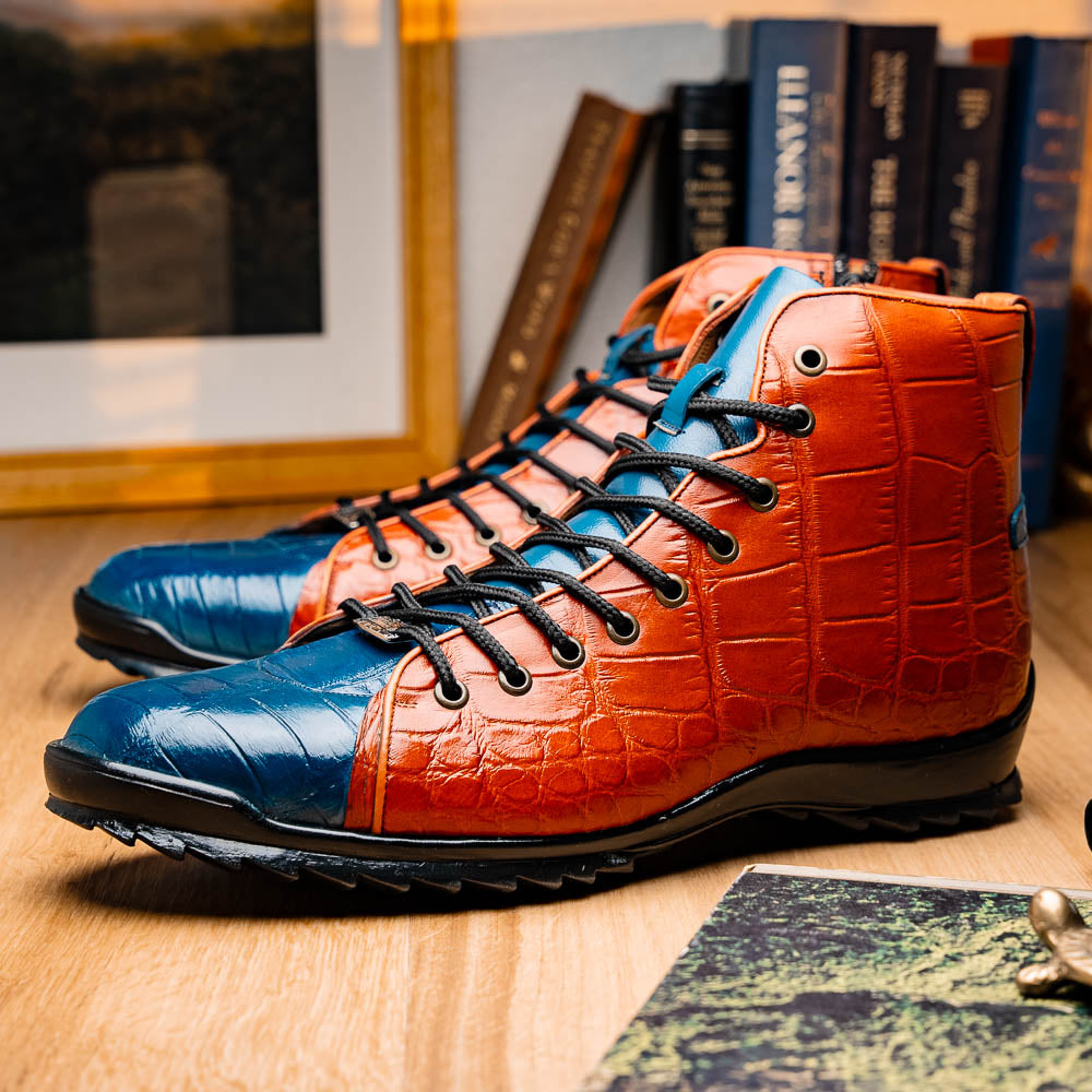 The Hermond Blue Jeans/Honey by Marco Di Milano is a luxury high-top with textured leather in orange and blue, black laces, metal eyelets, and a black rubber sole with unique hand-painted details.
