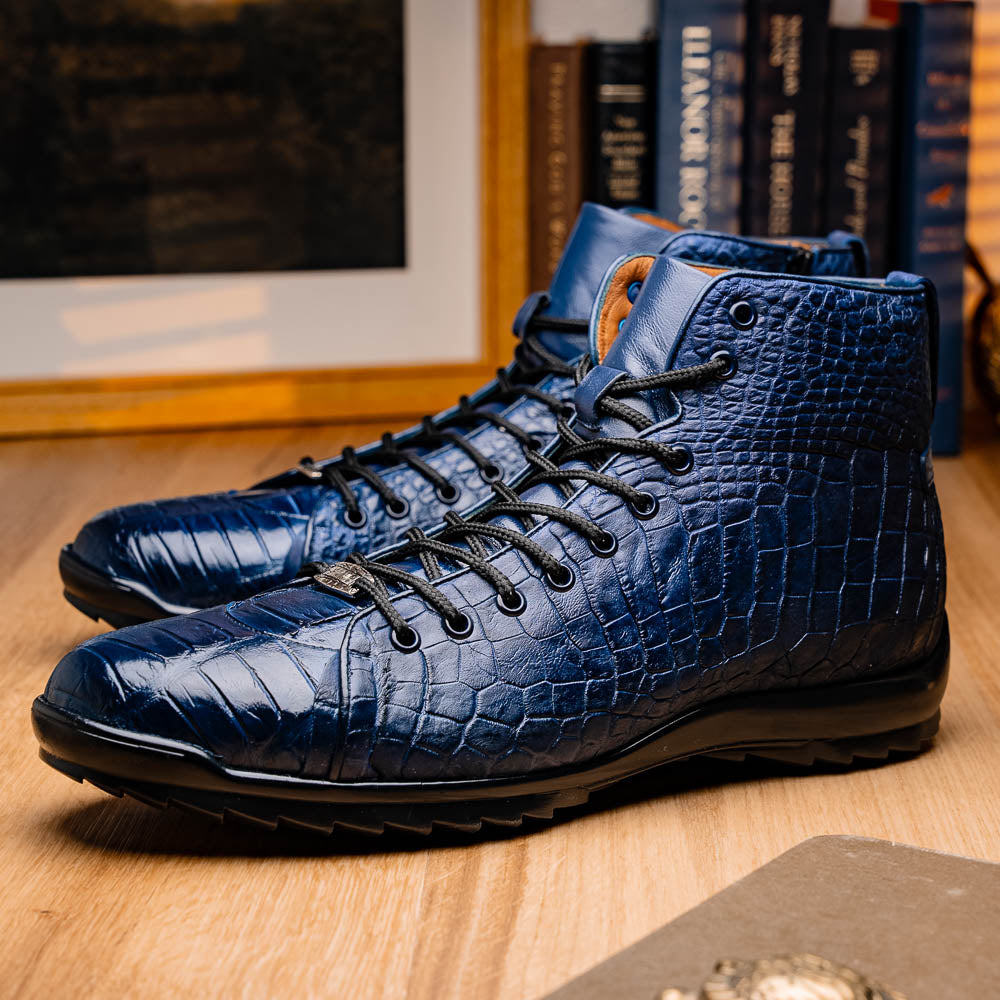 The Hermond Navy by Marco Di Milano: luxury high-top shoes in blue crocodile-patterned leather with genuine exotics, black laces, and black rubber soles—one shoe stands upright, the other lies on its side.
