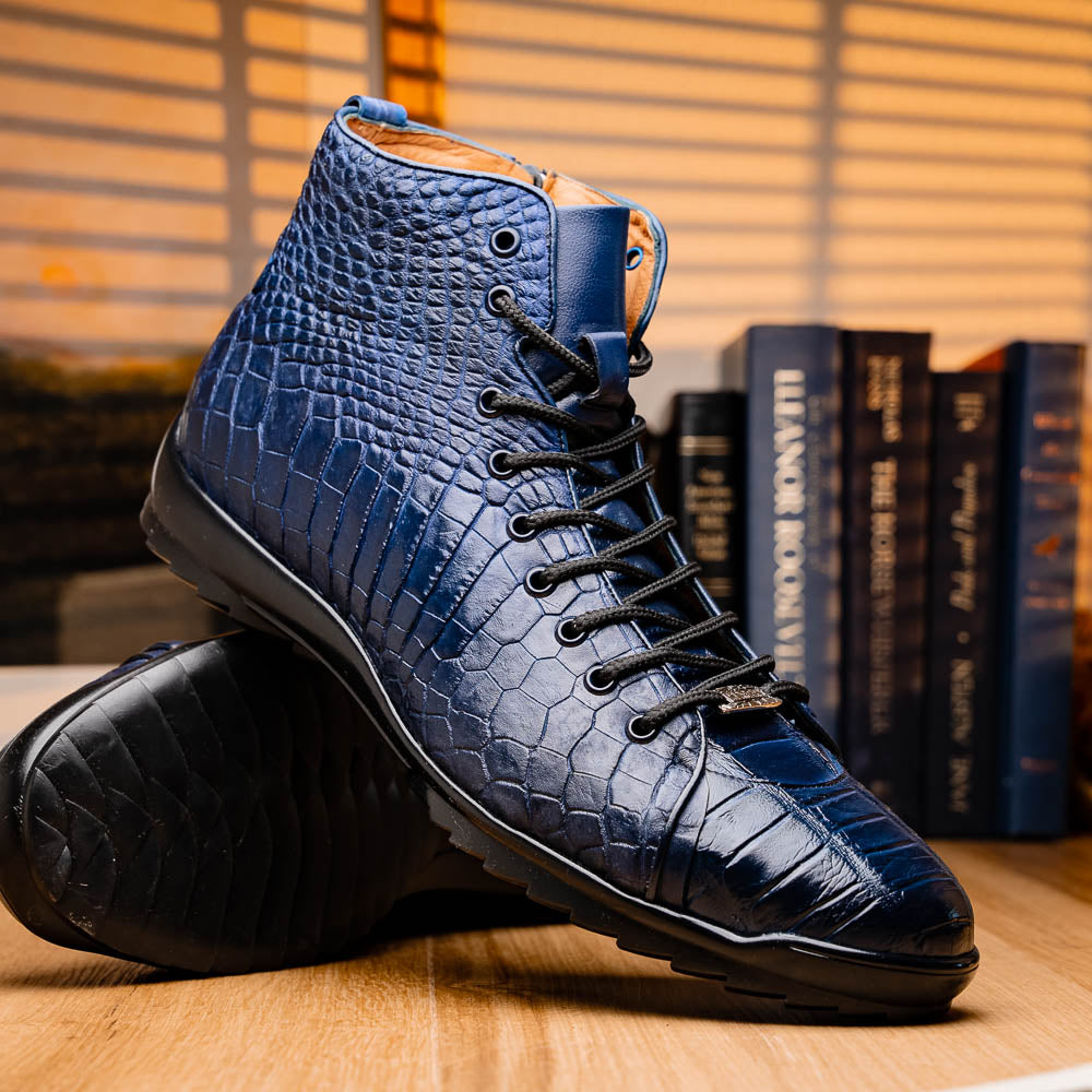 The Hermond Navy by Marco Di Milano: luxury high-top shoes in blue crocodile-patterned leather with genuine exotics, black laces, and black rubber soles—one shoe stands upright, the other lies on its side.