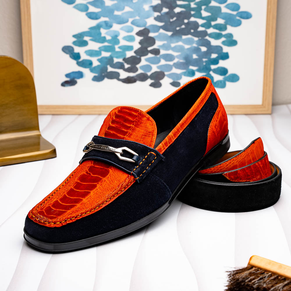 The Hugo Belt Orange / Navy by Marco Di Milano features navy blue ostrich leg suede with an orange textured leather accent near the silver buckle and engraved logos—a stylish match for luxury footwear.