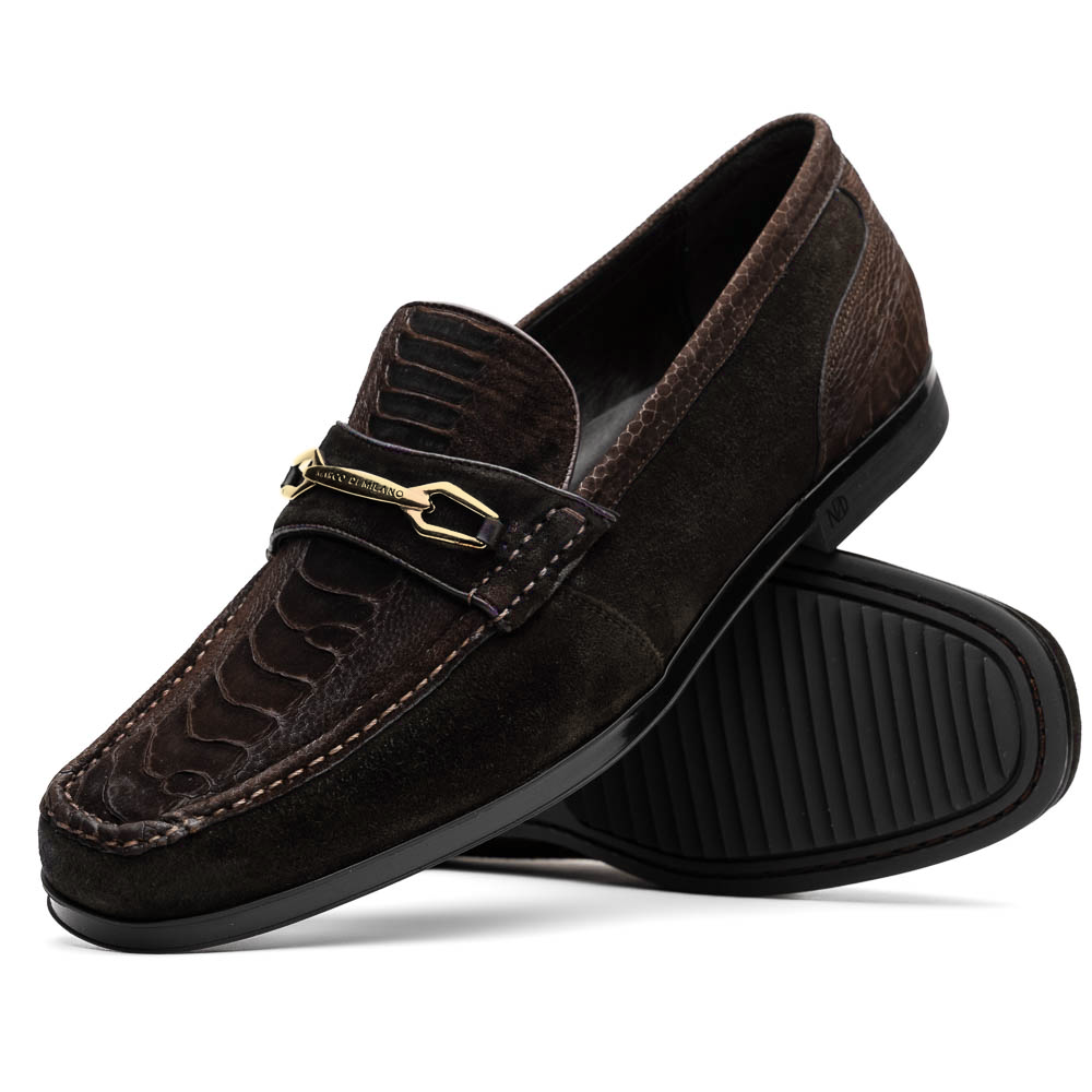 A pair of Marco Di Milano Hugo Brown sueded ostrich leg loafers with gold buckle detail and textured dark brown upper—one shoe stylishly propped on the other—epitomizes luxury footwear.
