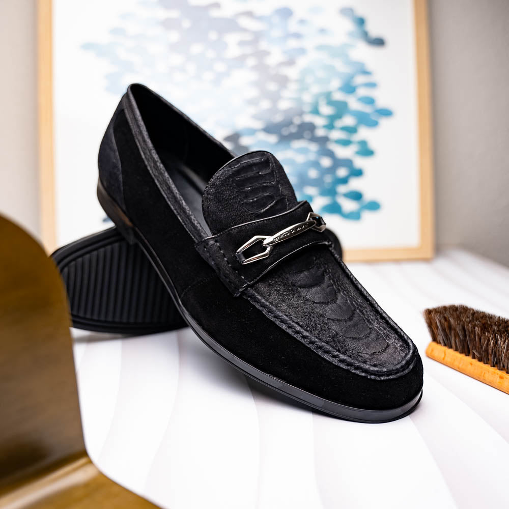 A pair of Marco Di Milano Hugo Black sueded ostrich leg loafers with metal chain detailing and textured rubber soles, one upright and one on its side, display refined luxury craftsmanship.