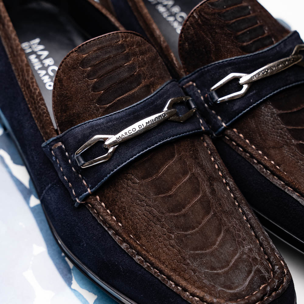 The Marco Di Milano Hugo Brown / Navy men's loafers feature dark brown textured leather, navy suede trim, a metal buckle detail, and black rubber soles for a luxurious look.