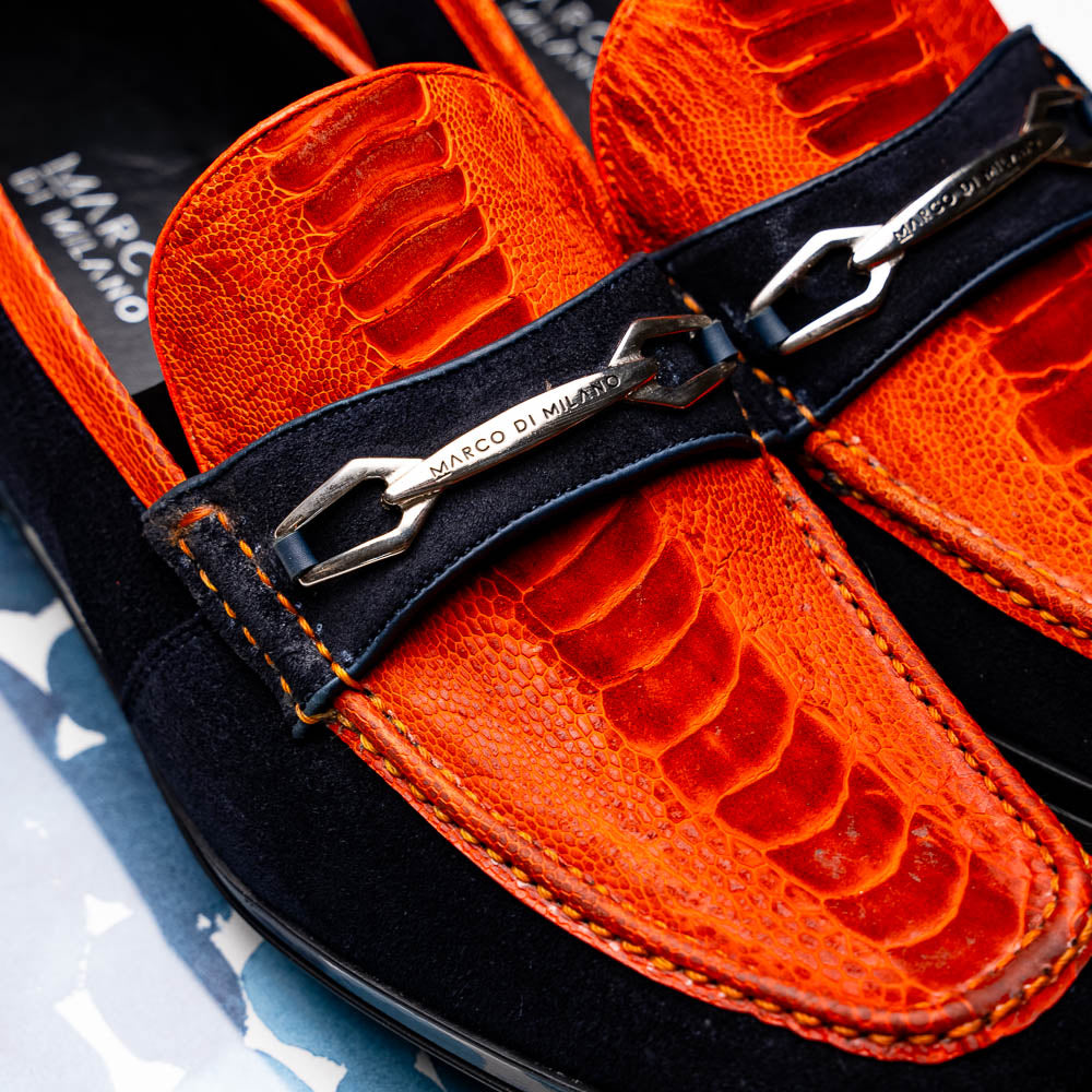 The Hugo Orange / Navy by Marco Di Milano is a men's loafer in orange crocodile-textured leather with navy suede accents, silver bit detail, and a black rubber sole with red stitching—ideal for luxury footwear fans.