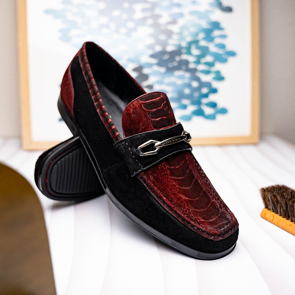 The Marco Di Milano Hugo Wine / Black men's loafers feature burgundy textured leather, black suede panels, metal buckles, and black rubber soles with red accents—luxury footwear for refined style.