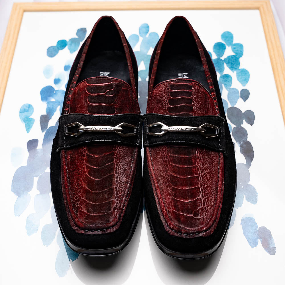 The Marco Di Milano Hugo Wine / Black men's loafers feature burgundy textured leather, black suede panels, metal buckles, and black rubber soles with red accents—luxury footwear for refined style.