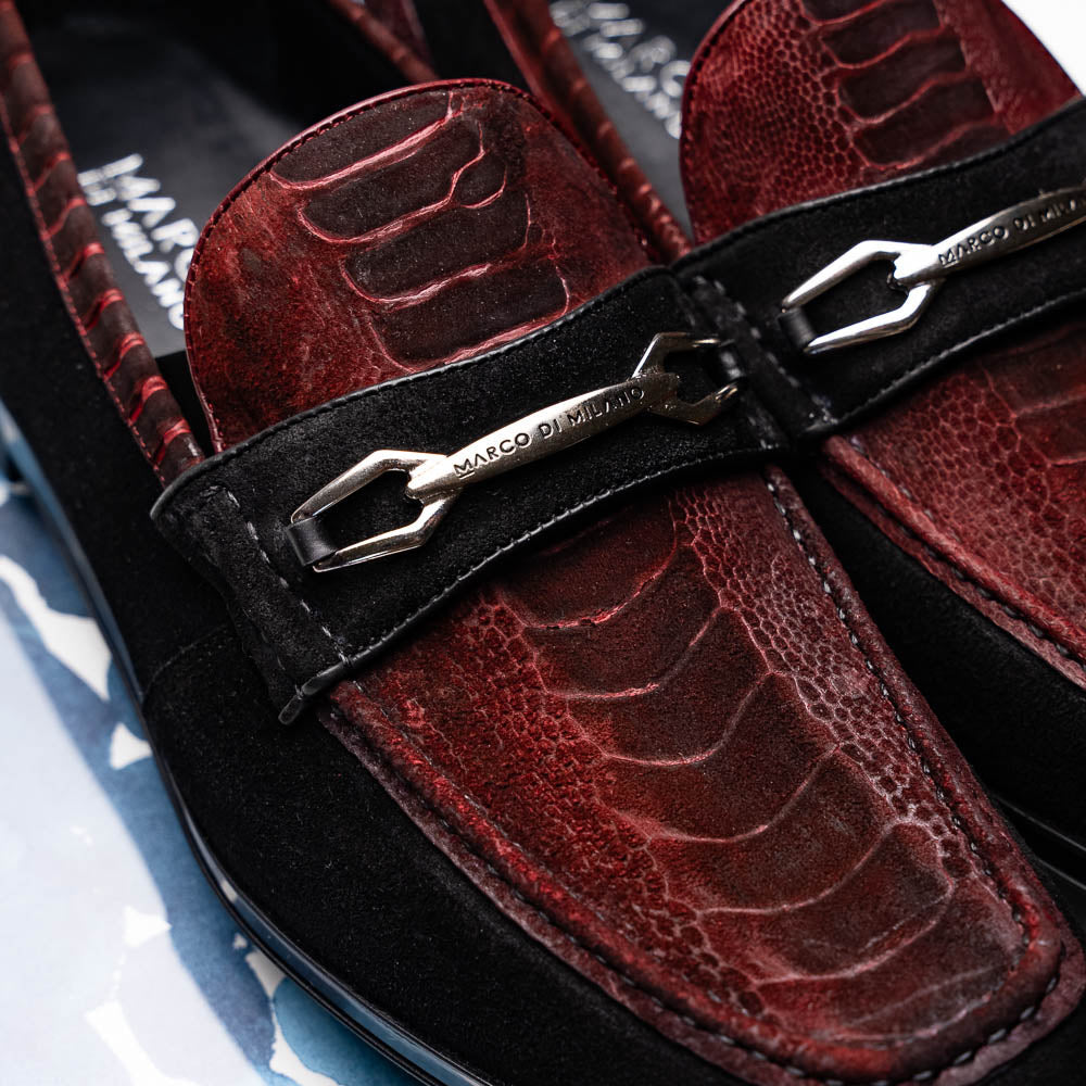 The Marco Di Milano Hugo Wine / Black men's loafers feature burgundy textured leather, black suede panels, metal buckles, and black rubber soles with red accents—luxury footwear for refined style.