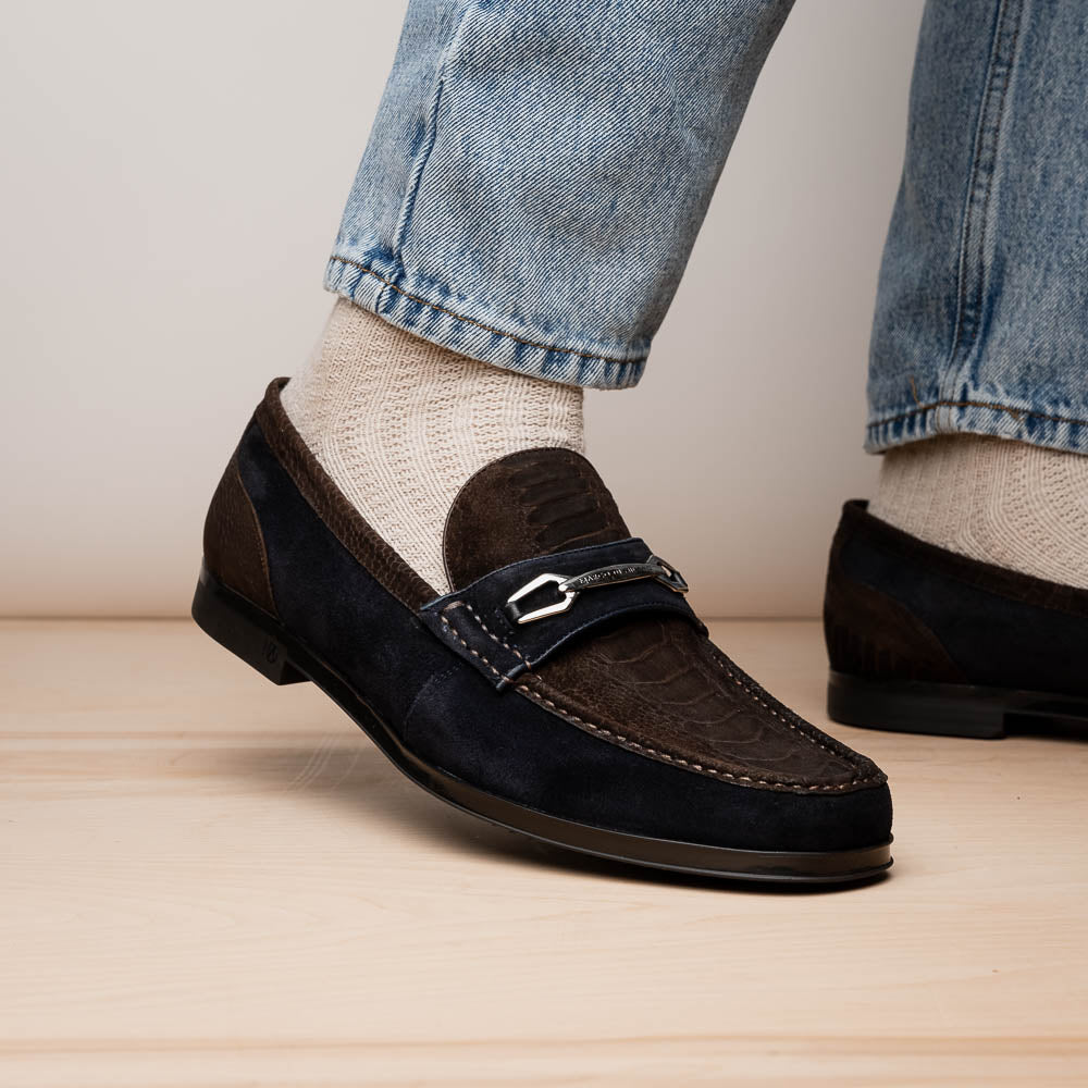 The Marco Di Milano Hugo Brown / Navy men's loafers feature dark brown textured leather, navy suede trim, a metal buckle detail, and black rubber soles for a luxurious look.