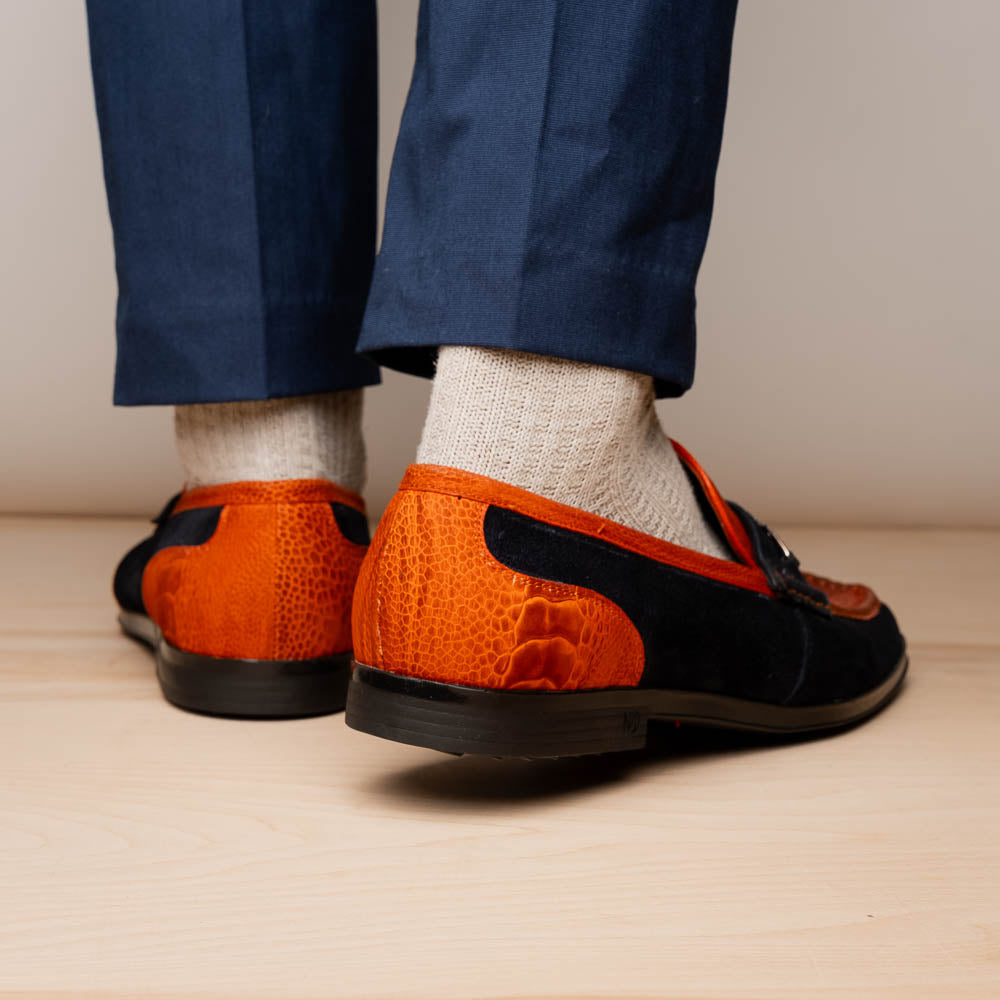 The Hugo Orange / Navy by Marco Di Milano is a men's loafer in orange crocodile-textured leather with navy suede accents, silver bit detail, and a black rubber sole with red stitching—ideal for luxury footwear fans.