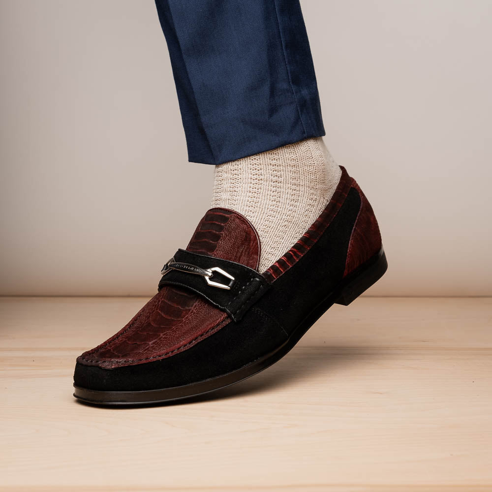 The Marco Di Milano Hugo Wine / Black men's loafers feature burgundy textured leather, black suede panels, metal buckles, and black rubber soles with red accents—luxury footwear for refined style.