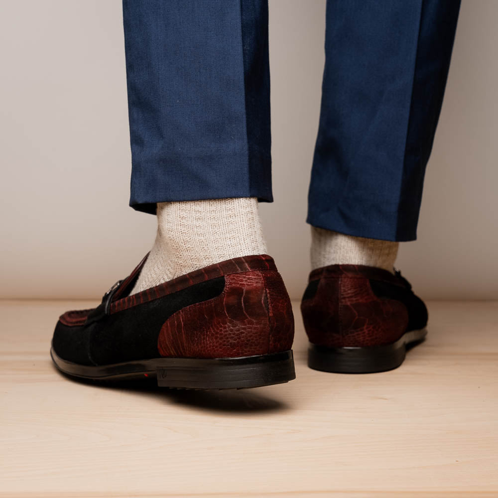 The Marco Di Milano Hugo Wine / Black men's loafers feature burgundy textured leather, black suede panels, metal buckles, and black rubber soles with red accents—luxury footwear for refined style.