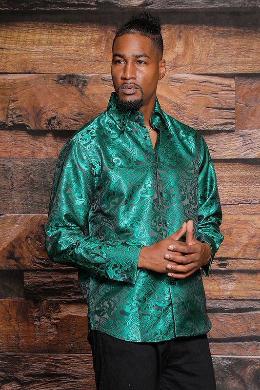 A man stands before a wooden wall wearing the MANZINI MZT-100 Paisley Long Sleeve Satin Hunter Shirt with Links by Manzini and black pants—an eye-catching, formal look.