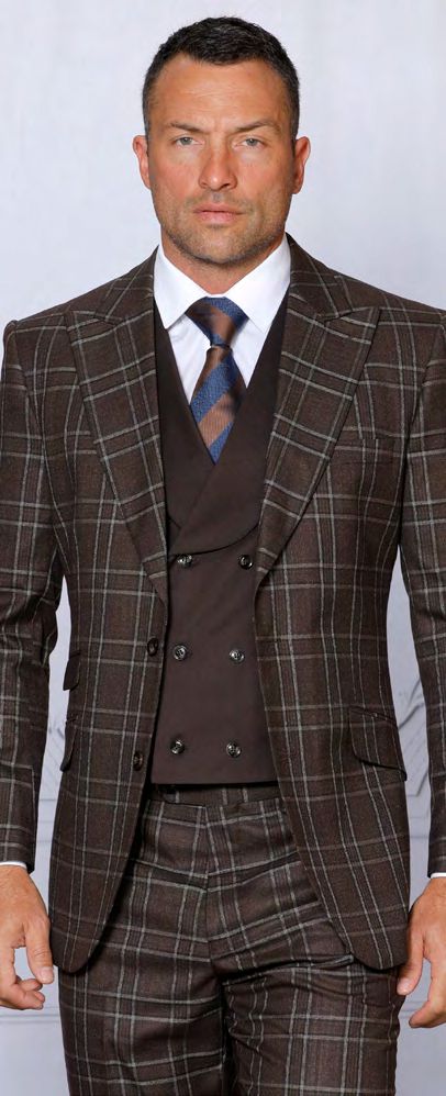 Clad in the INSOMNIA PARIS-2 3PC tailored fit brown suit from Insomnia, a man exudes confidence as he poses against a plain background, wearing the ensemble complete with a double-breasted vest and complemented by a brown and blue striped tie.