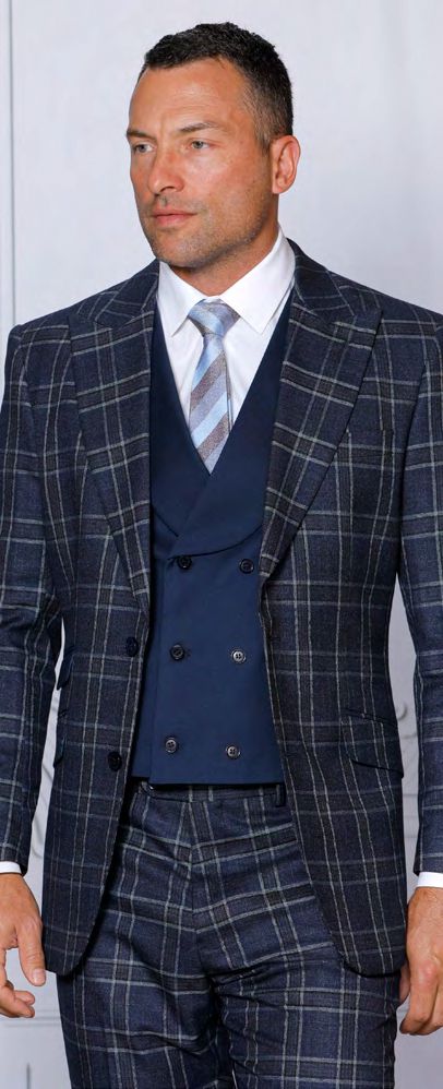 A person confidently displays the INSOMNIA PARIS-2 3PC Tailored Fit Midnight Suit by Insomnia, complemented by a white shirt and striped tie, against a plain background.