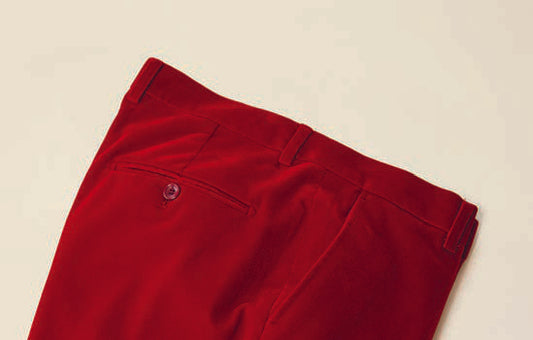 The Inserch Velvet Pants P502-30 in red, from the brand Inserch, showcase a modern fit and are crafted from luxurious velvet fabric. Gracefully displayed on a plain surface, these pants feature a single back pocket with a button, effortlessly blending style and comfort.