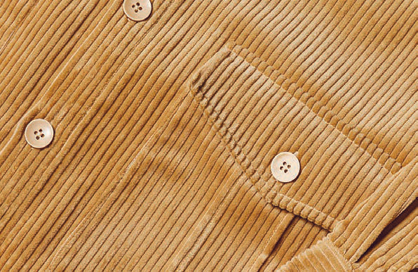 A person wearing the Inserch 4-Pocket Cord Suit BL267-09 Khaki with an adjustable back tab over a white turtleneck sweater.