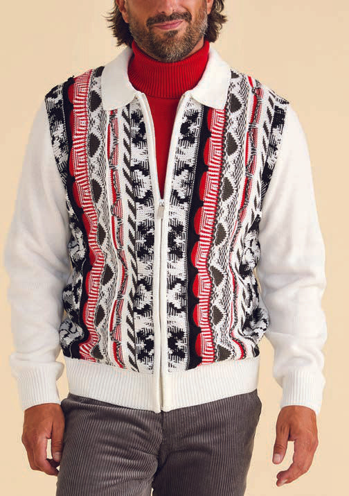 A man wears the Inserch 3D Intarsia Full Zip Sweater SW907-02 in white, featuring bold black, red, and white vertical stripes, styled over a red turtleneck and gray corduroy pants.