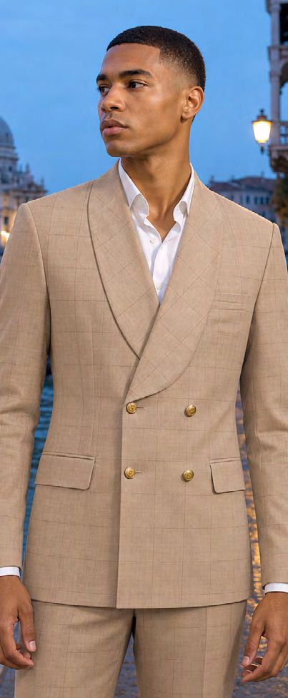 A man wearing a MANZINI MERLOT 2PC Shawl Lapel Window Pane Double Breasted Tan Tailored fit suit jacket with a shawl lapel and gold buttons over a white dress shirt.