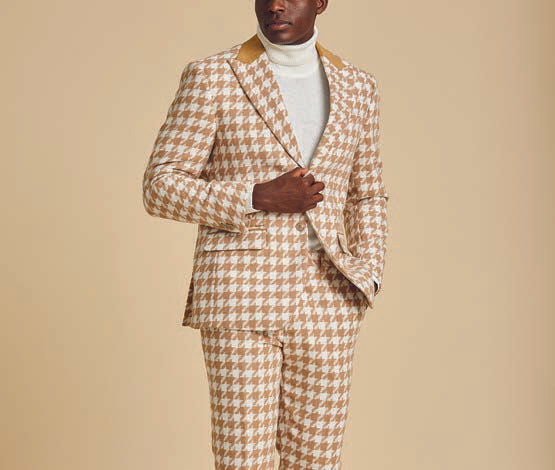 A man models the Inserch Houndstooth Suit BL264-09 Khaki by Inserch, paired with a white turtleneck, standing against a beige background and highlighting the suit's modern fit.