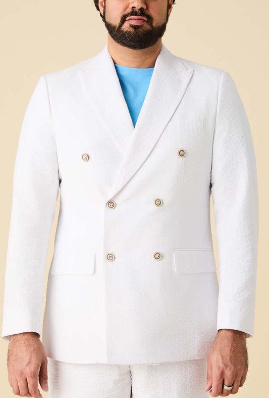A man models the Inserch Double Breasted Seersucker Peak Lapel Blazer BL506-00002 in white over a light blue shirt, shown from mid-face to waist against a beige background.