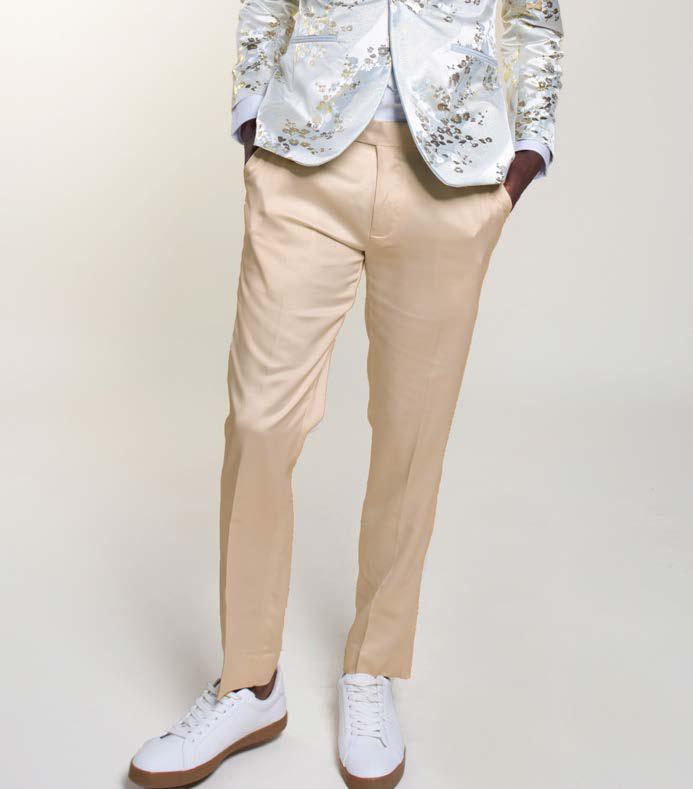 A person is wearing Inserch Stretch Satin Pants P3901-00105 Ivory by Inserch, paired with white sneakers with brown soles and a white blazer featuring metallic floral patterns, standing against a plain background.