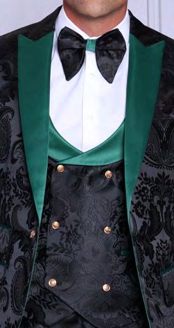 A man wears the Manzini Armani 3-Piece Slim Fit Fancy Woven Black Green Suit featuring a green satin lapel, matching waistcoat, bow tie, black satin floral filigree pattern, and gold buttons by Manzini.