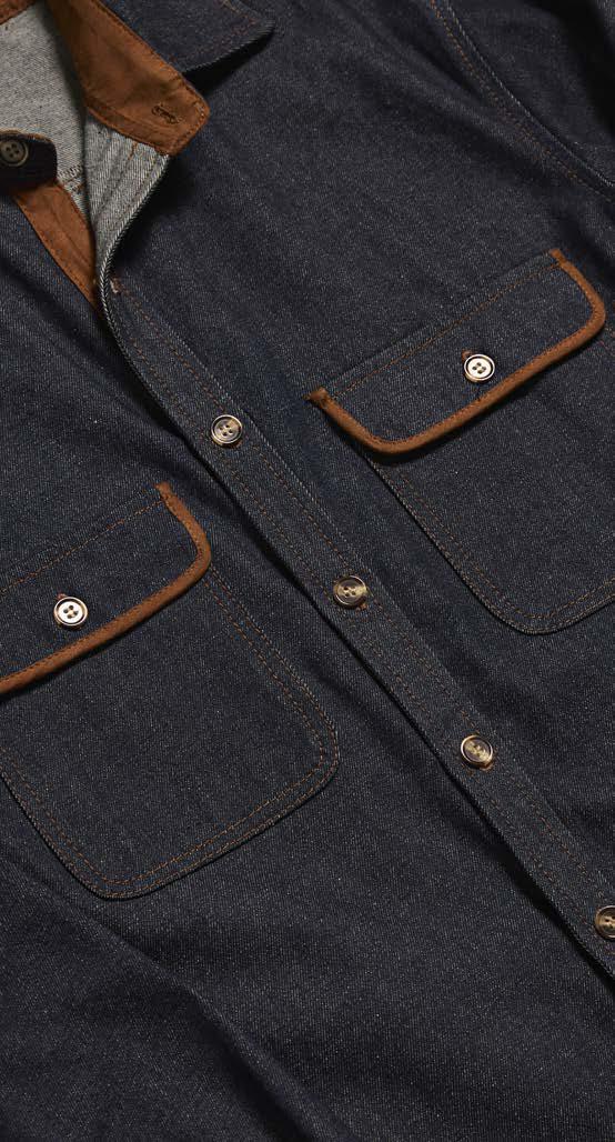 Someone stands against a beige background wearing the Inserch Denim Shirt w/ Suede Trim 2pc Set SE005-P005-00195 Indigo from Inserch, featuring a dark blue two-pocket jacket with brown suede trim and matching denim pants.