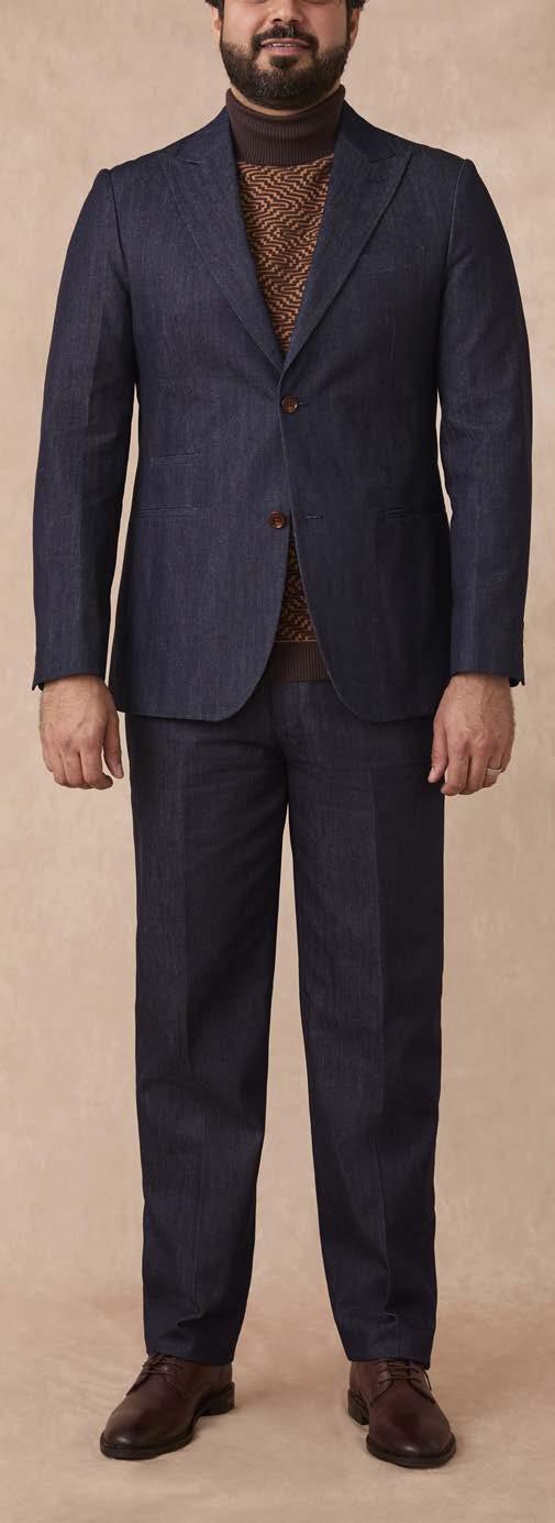 A man stands facing forward against a beige background, wearing the Inserch Denim 2pc Suit SU660281L-00195 Indigo by Inserch, styled with a brown patterned sweater and brown dress shoes.