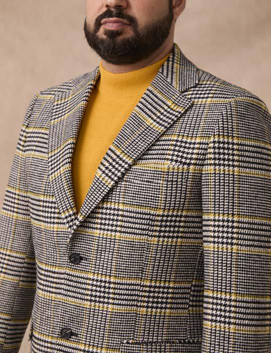 A man wearing a yellow turtleneck and an Inserch Glenn Check Wool Blend Blazer BL282-00041 in Black/White stands against a neutral background.