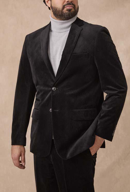 A man wearing the Inserch Velvet Diagonal Blazer BL275-00001 Black, featuring a notch collar, styled over a light gray turtleneck sweater with black pants, stands against a neutral background.