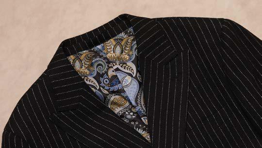 A man wearing the Inserch Wool Blend Flannel DB Stripe Suit SU660280L-00001 Black by Inserch along with a light-colored shirt, standing against a plain beige background.