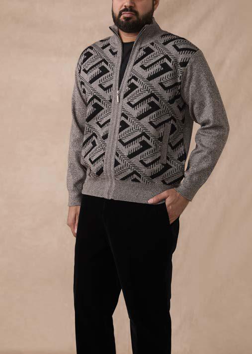 A man wearing the Inserch Full Zip Sweater SW616-00033 Grey, featuring a black geometric pattern, paired with black pants, stands against a beige background.