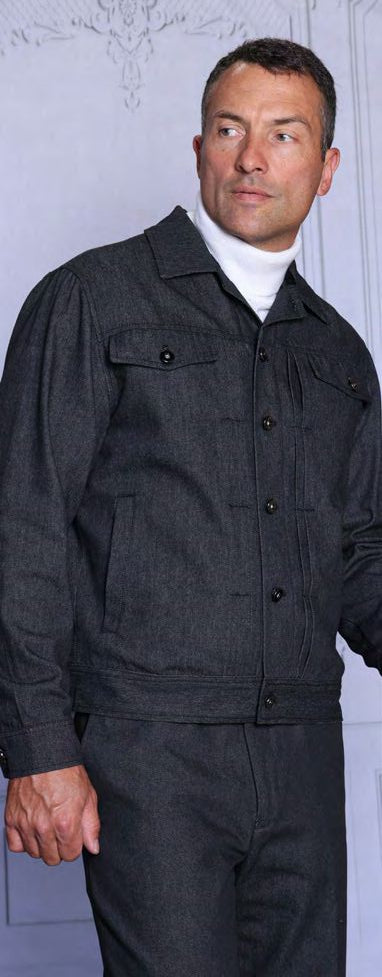 A man wears the Insomnia GLENLIVET 2PC Denim Casual Jacket & Pants Black Set over a white turtleneck, standing in front of a light-colored wall.