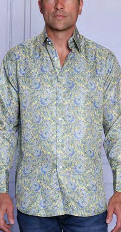 A man wears the INSOMNIA MZT-205 Woven Satin Yellow Shirt by Insomnia, a long-sleeved, button-up with blue and yellow floral paisley design and French cuffs, standing against a light-colored background.