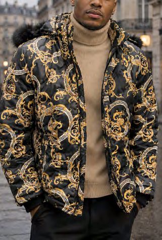 A person wearing an Insomnia MZW-410 Soft Padded Poly Zip-up Jacket w/ Removable Black Faux Fur Hood, featuring an ornate gold pattern over a tan turtleneck sweater.
