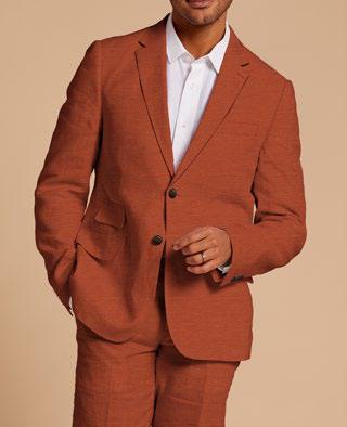 A man wearing the Inserch Slim Linen Blazer SU880-00109 in Burnt Orange by Inserch, paired with a white shirt, stands against a beige background.