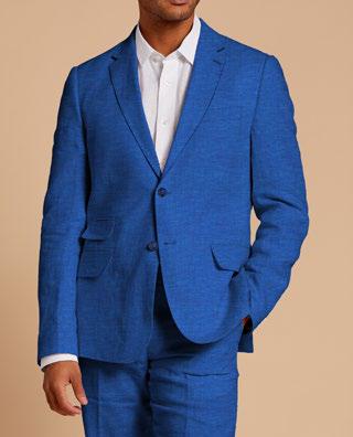 An individual wearing the Inserch Slim Linen Blazer SU880-00181 in River Blue, paired with a crisp white shirt, stands against a beige background, emphasizing the outfit's classic elegance.
