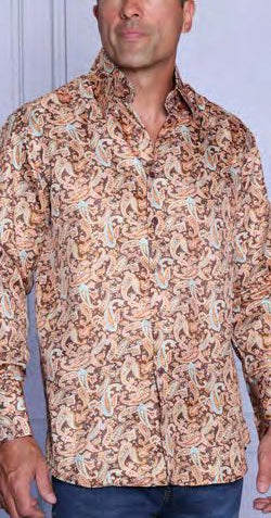 A man wearing the INSOMNIA MZT-204 Woven Satin Copper Shirt by Insomnia, featuring long sleeves, a button-up front, and an abstract brown, beige, and turquoise pattern with elegant French cuffs, stands before a light wall.