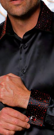 A man fastens a cufflink while wearing the Insomnia INSOMNIA IN-118 Slim Fit Satin Stone Collar & Cuff Black Red Shirt, featuring red dot accents on the stone collar and French cuffs.