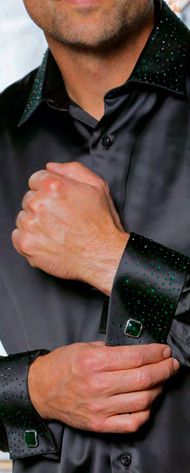 A man adjusts the cuff of his INSOMNIA IN-118 Slim Fit Satin Stone Collar & Cuff Black Green Shirt by Insomnia, featuring green-studded French cuffs and matching green cufflinks.