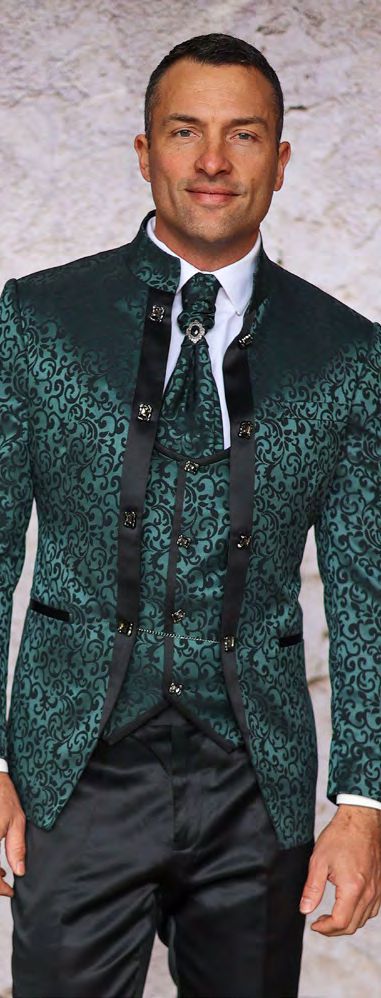 A man models the Insomnia MANZINI HAVANA 3-Piece Slim Fit Shiny Satin Pattern Banded Collar Jade Suit with a floral-patterned tie, accented by black details against a textured light gray backdrop. The outfit, complemented with black pants, is designed for dry clean only care.