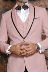 A gentleman in the Insomnia Sunset 3PC Slim Fit Rose Gold Tuxedo Suit with black trim, wearing a reversible vest over his white shirt and accessorizing with a black bow tie, is clasping his hands.