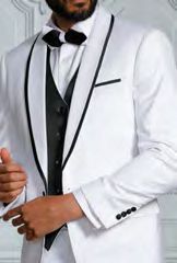 A confident man in an Insomnia INSOMNIA SUNSET 3PC Slim Fit White Black Tuxedo Suit, featuring a white jacket with black trim and a black bow tie, paired with a sleek reversible vest, stands against a white background.