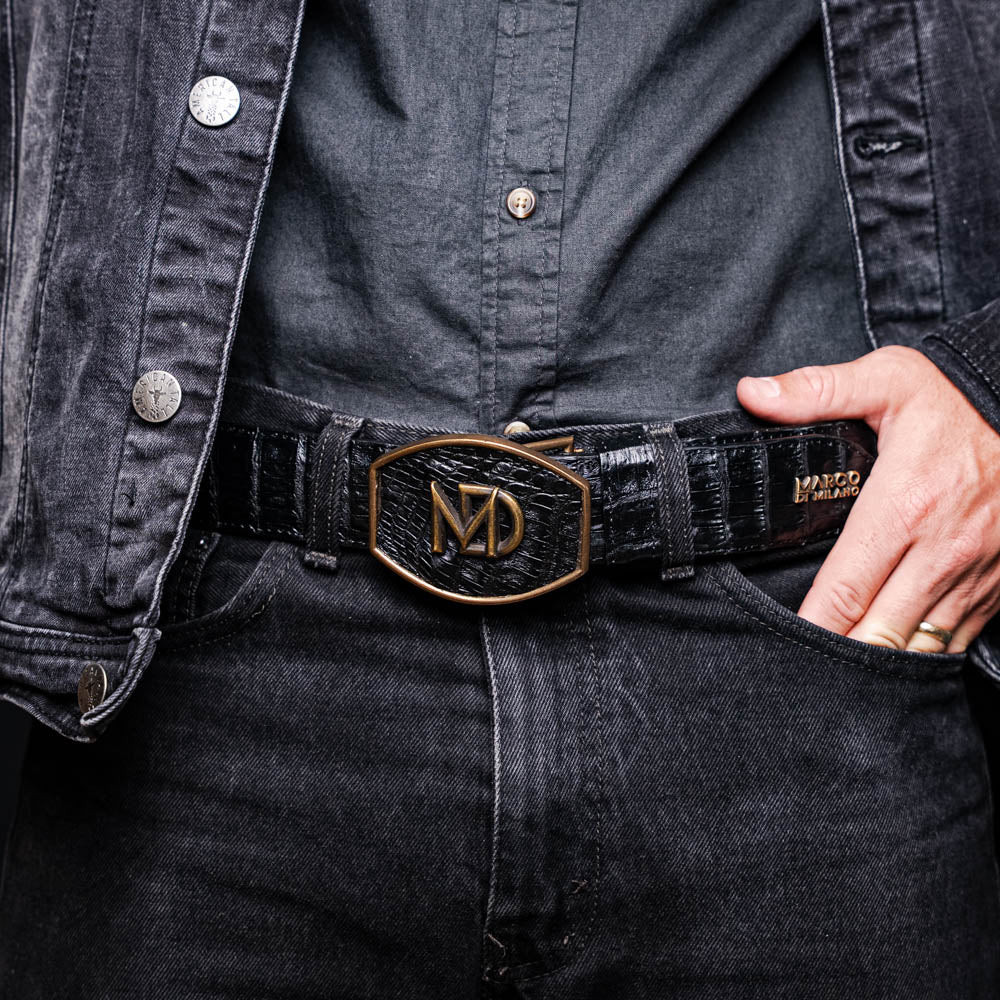 The Iowa Belt Black by Marco Di Milano is crafted from genuine black caiman skin with a crocodile texture, featuring a bold gold "MD" buckle and embossed branding—an eye-catching Western belt for any outfit.