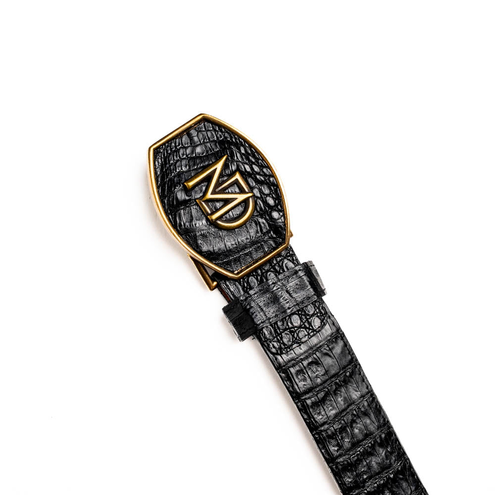 The Iowa Belt Black by Marco Di Milano is crafted from genuine black caiman skin with a crocodile texture, featuring a bold gold "MD" buckle and embossed branding—an eye-catching Western belt for any outfit.