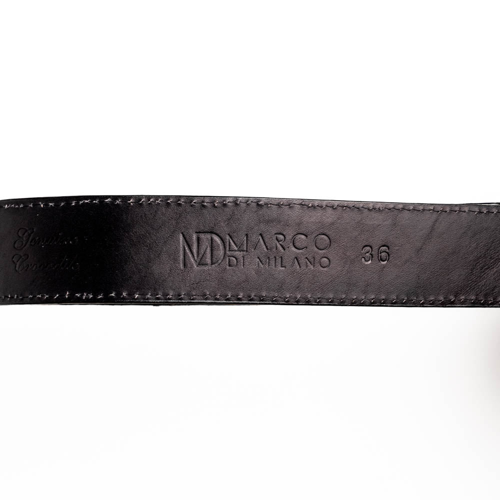 The Iowa Belt Black by Marco Di Milano is crafted from genuine black caiman skin with a crocodile texture, featuring a bold gold "MD" buckle and embossed branding—an eye-catching Western belt for any outfit.