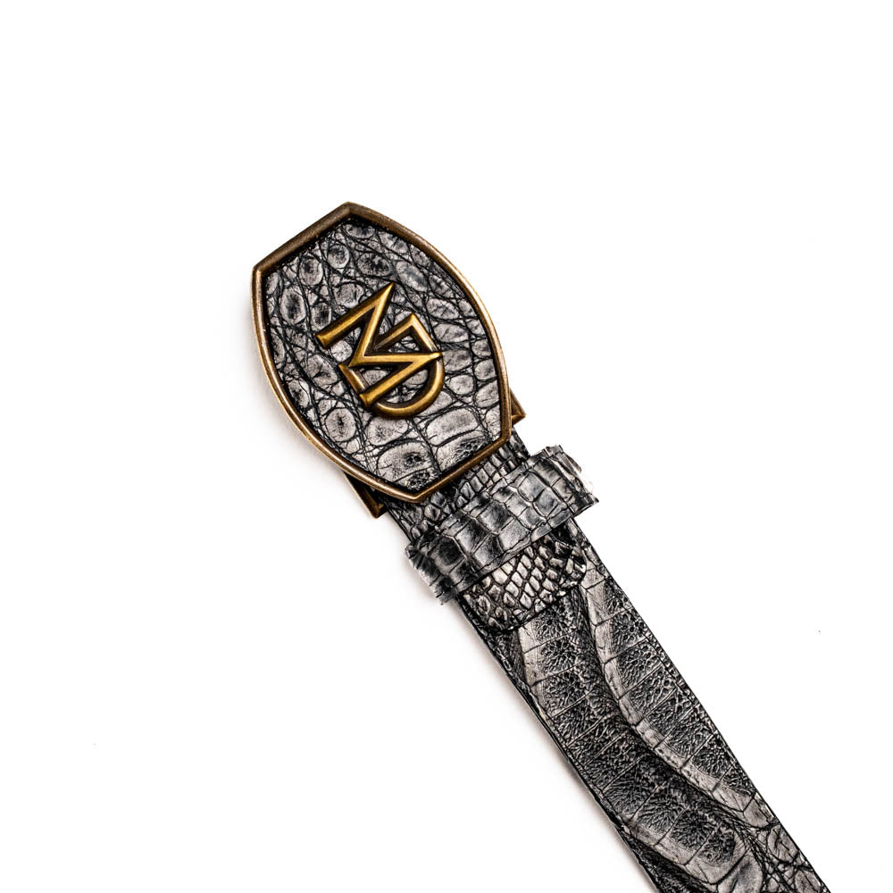 The Marco Di Milano Iowa Belt Stone Gray features genuine caiman skin and a bold gold "MD" buckle on a textured background, combining luxury with standout Western style.