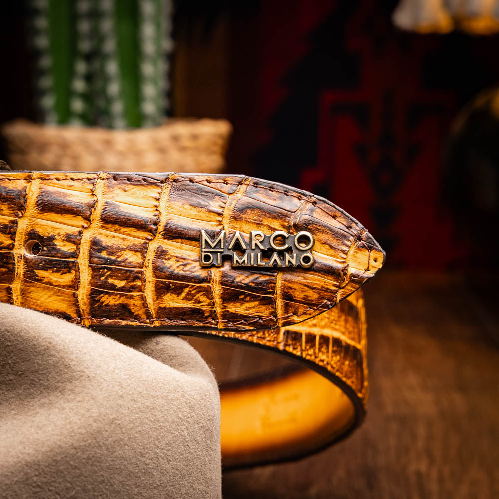 The Iowa Belt Mustard Brown by Marco Di Milano features genuine caiman crocodile leather and a bold gold "MD" buckle, elegantly displayed on a white background—showcasing the brand's signature luxury style.